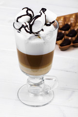 Latte, cappuccino with marshmallow on light background. Chocolate topping