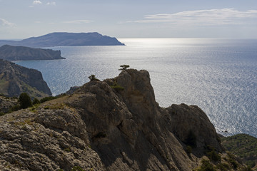 Silhouettes of coastal mountains against the background of the sea.