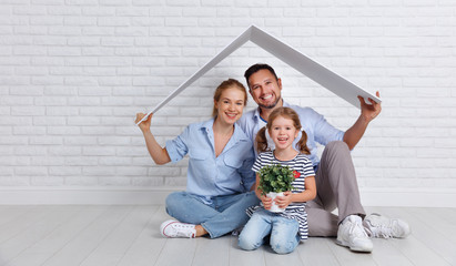 concept housing   young family. Mother father and child in new house with  roof at empty brick wall