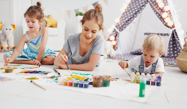 children's creativity. mother and children draw paints in   playroom