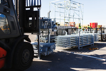 Modern electric forklift carries special metal structures for the construction and erection works