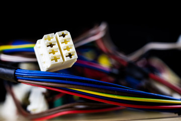 Electric cables, plugs and connectors on a wooden workshop table. Accessories and electrical components.