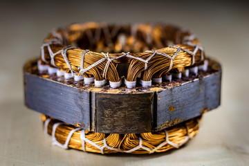 Stator of an electric motor on a wooden workbench. Accessories and electrical components.