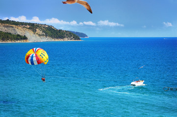 Parasailing with boat over sea in beautiful summer day