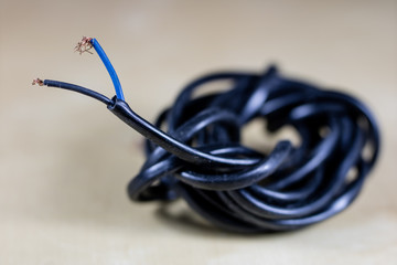Electric cables, plugs and connectors on a wooden workshop table. Accessories and electrical...