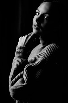 Very beautiful and sincere black and white portrait of an attractive girl on which shines the light from the window