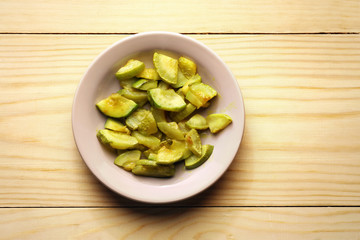 Zucchini in a plate on a wood background