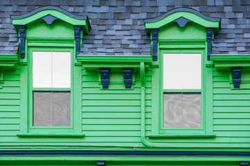 Fototapeta na wymiar Ornate Upper Windows on Bright Green House