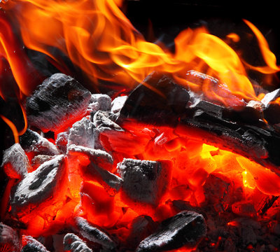 Closeup of charcoal burning with fire flames.Burning charcoal texture.