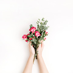 Woman hands hold rose flowers and eucalyptus branch bouquet on white background. Flat lay, top view spring hero header background.