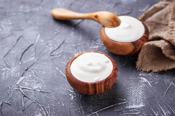 White Greek yogurt in wooden bowl