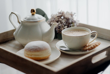 Donuts on plate on woode board with hot coffee for breakfast