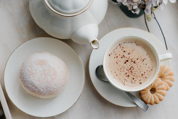 Donuts on plate on woode board with hot coffee for breakfast