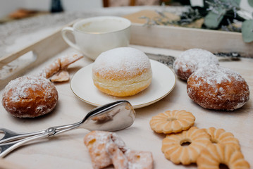 Donuts on plate on woode board with hot coffee for breakfast