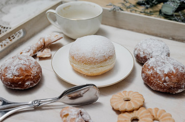 Donuts on plate on woode board with hot coffee for breakfast