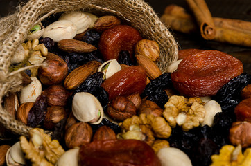 nuts, dried fruits, pistachios and other scattered from the bag on the table