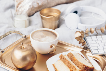 Cozy composition with tray and breakfast in bed. Still life background with gold decorations