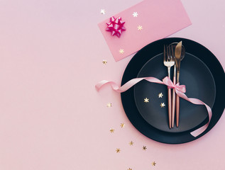 Top view of the beautifully decorated table with plate, card and cutlery on luxurious background. Party concept
