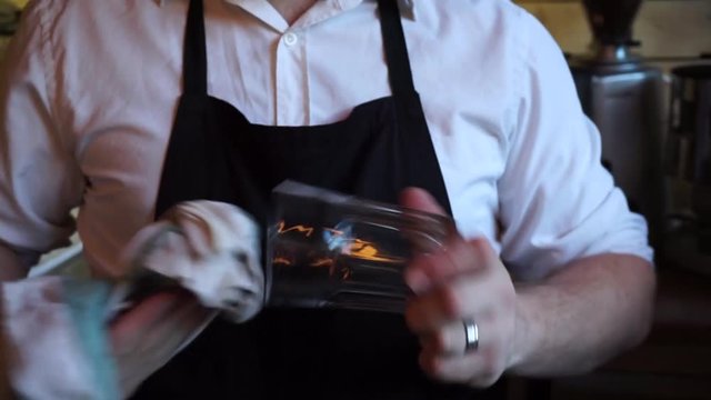 Barista cleaning a glass with white cloth