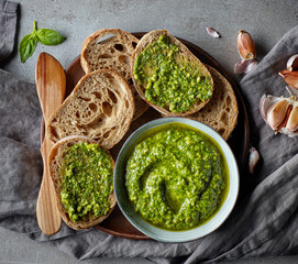 Bowl of basil pesto on grey table