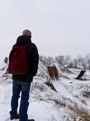 Middle age man standing in beautiful winter landscape . Man viewing on abandoned freestyle...