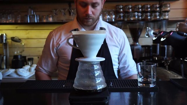 V60 coffee maker dripping barista waiting for second pour over