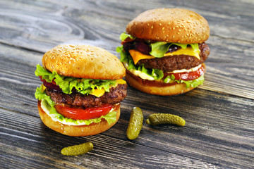 Delicious burgers on a wooden table.