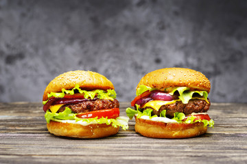 Delicious burgers on a wooden table.