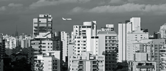 Urban landscape with plane in the sky