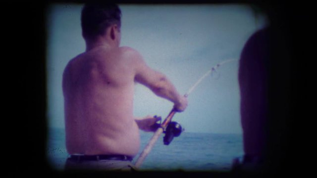 Archival footage of a man deep sea fishing