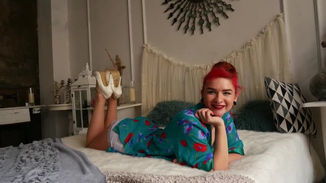Beautiful red-haired girl on the bed. A woman in a pinup style at a photo shoot.