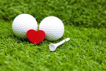 Red heart with golf ball on green grass meaning to golfer with love