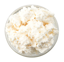 Cottage cheese in glass bowl on a white background, top view