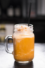 Thai Iced Tea Slushie in mason jar, dark background
