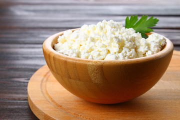 Home cottage cheese in a bowl on a wooden table.