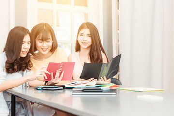 Portrait of happy group of young women student studying are sitting together and smile using modern laptop computers and wireless connection to internet in classroom .Education, teamwork  concept,tone