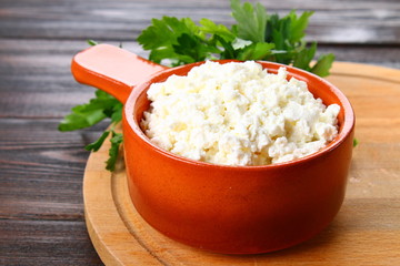 Home cottage cheese in a bowl on a wooden table.