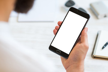 The man uses a smartphone with a white screen for the mock up. Concepts of using mobile devices,...