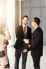 Corporate teamwork partnership concept . Businessmen presenting and shaking hands to colleagues at office meeting room.