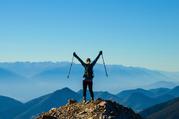 Woman hiker celebrating on a mountain summit
