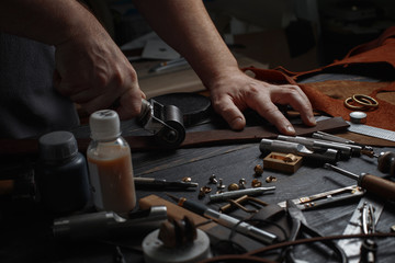 Man working with leather using crafting DIY tools.