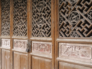 Chinese Traditional wood carvings, disused wood windows covered with dust, beautiful wood carvings of Chinese traditional legend story.