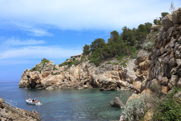 Fototapeta na wymiar Europe, Spain, Balearic Islands, Mallorca. Cala Banyalbufar. Beachfront swimming. Harbor, Sunbathers. Boats.