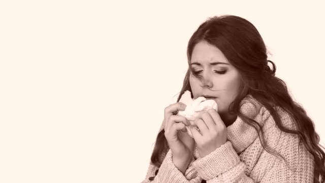 Sick freezing woman sneezing in tissue having cough. Girl wearing warm sweater being cold and trembling. Flu or other virus. Health care."
