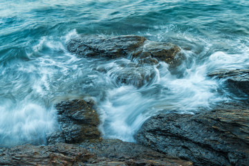 Wave in sea hitting rock on coast