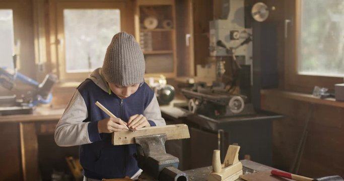 Cute Boy marking and measuring a piece of Wood