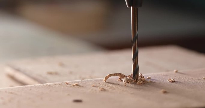 Electric driller on wooden plank