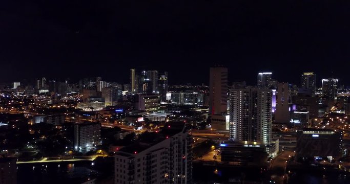 Aerial pan of city downtown at night with traffic