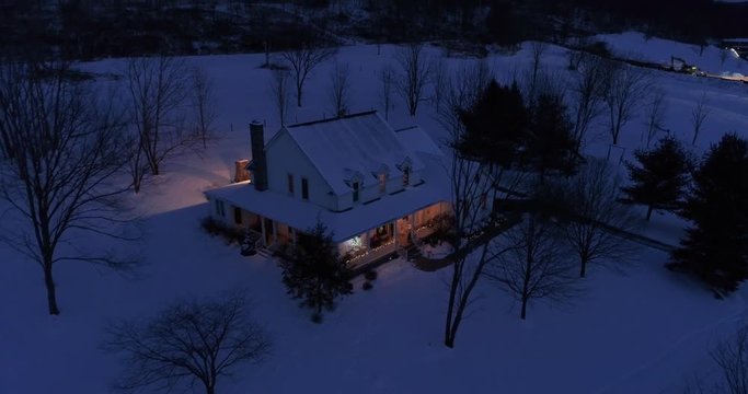 A high angle night aerial perspective of a farmhouse decorated for Christmas in the Pennsylvania countryside. Pittsburgh suburbs.  	