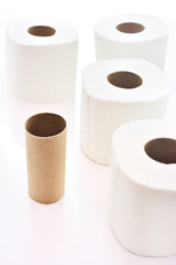 empty toilet paper roll among full toilet paper rolls in the white background